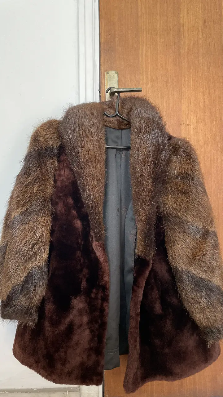 Tapado de piel natural marrón con detalles en marrón oscuro y mangas con textura. Ideal para el invierno, con forro interior y etiqueta de la marca Enri.
