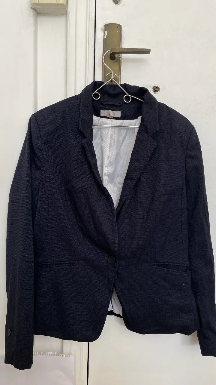 Elegante blazer de mujer, color azul oscuro, con un solo botón y bolsillos. Ideal para un look formal o de trabajo.