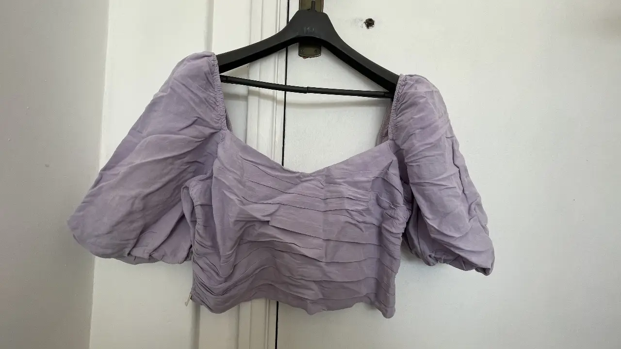 Blusa de mujer lila con mangas abullonadas y frunces en el frente. Ideal para un look elegante y moderno.