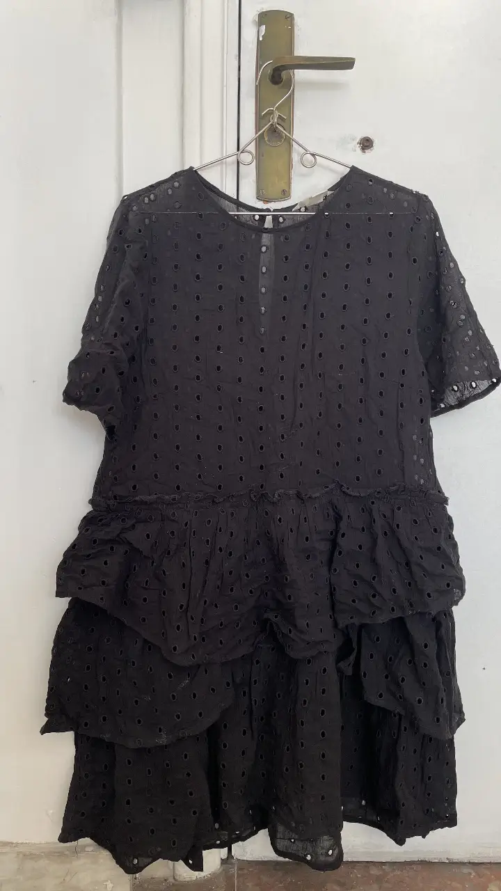 Vestido midi negro con detalles calados y volados. Talle 10 EUR, ideal para un look casual o de salida. Es holgado va para un L también.