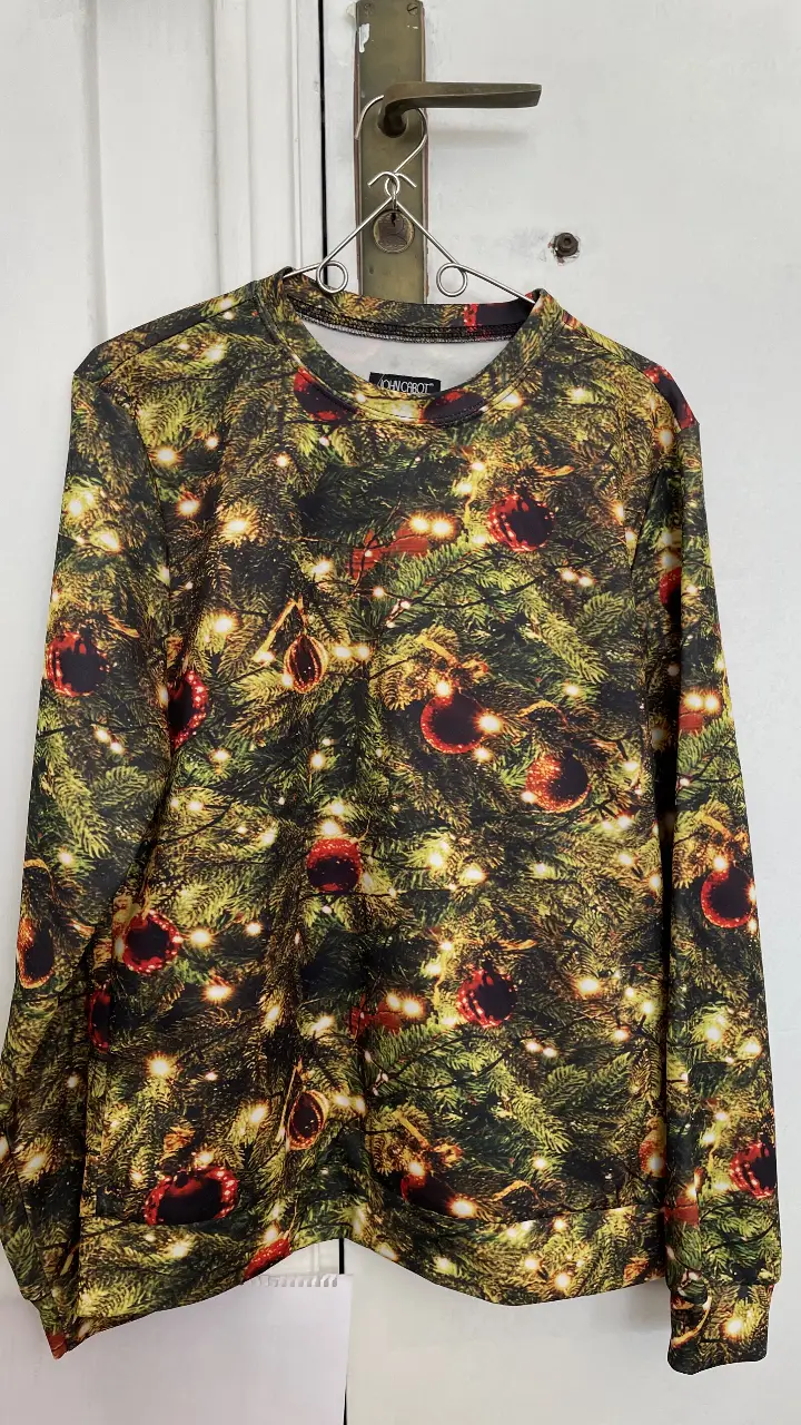 Buzo de cuello redondo con estampado navideño. Confeccionado en poliéster y elastano, ideal para las fiestas.