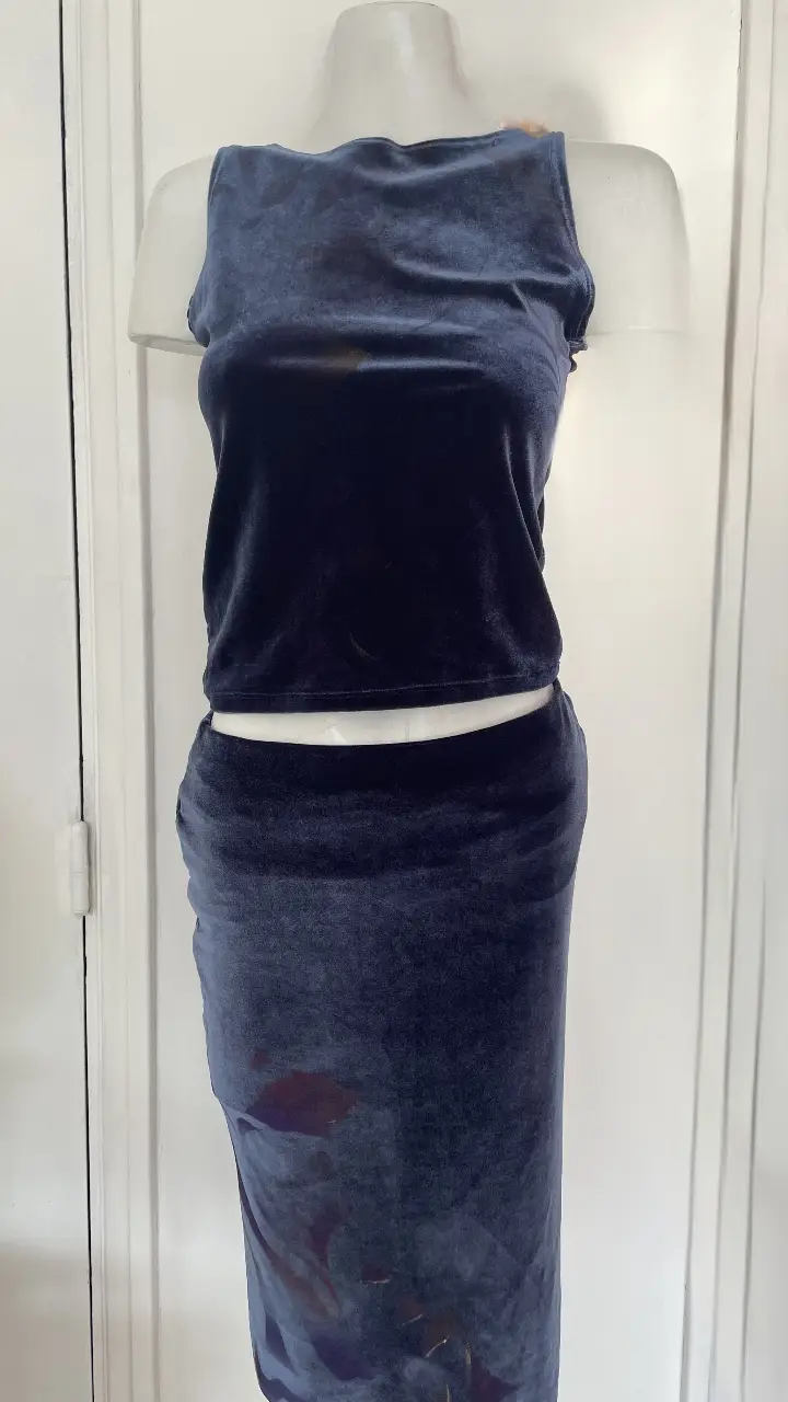 Conjunto de terciopelo azul oscuro, compuesto por un top sin mangas y una pollera larga con abertura lateral. Ideal para un look elegante y sofisticado.