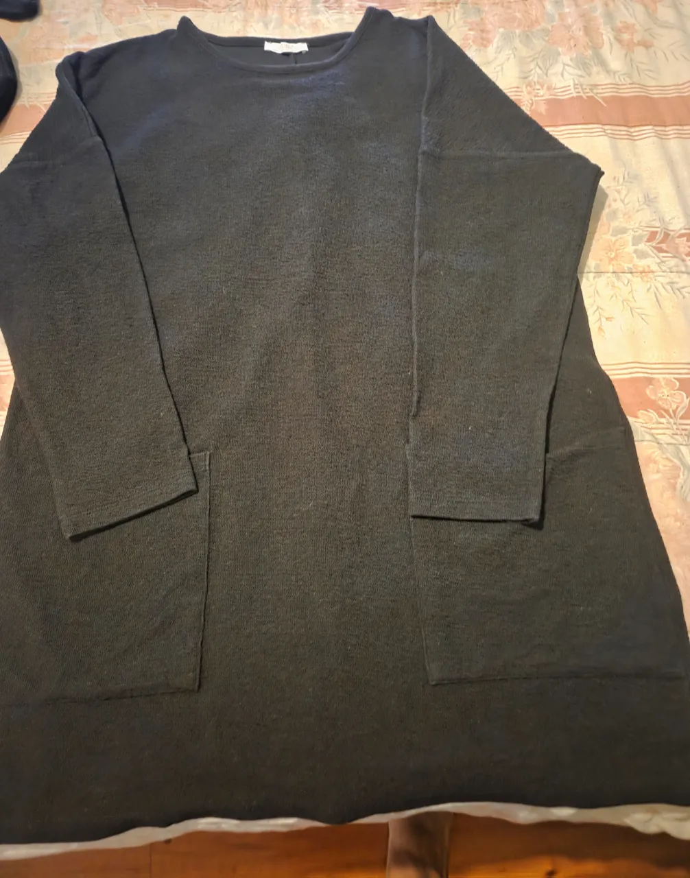 Vestido midi negro, de manga larga y bolsillos. Ideal para un look casual y cómodo.