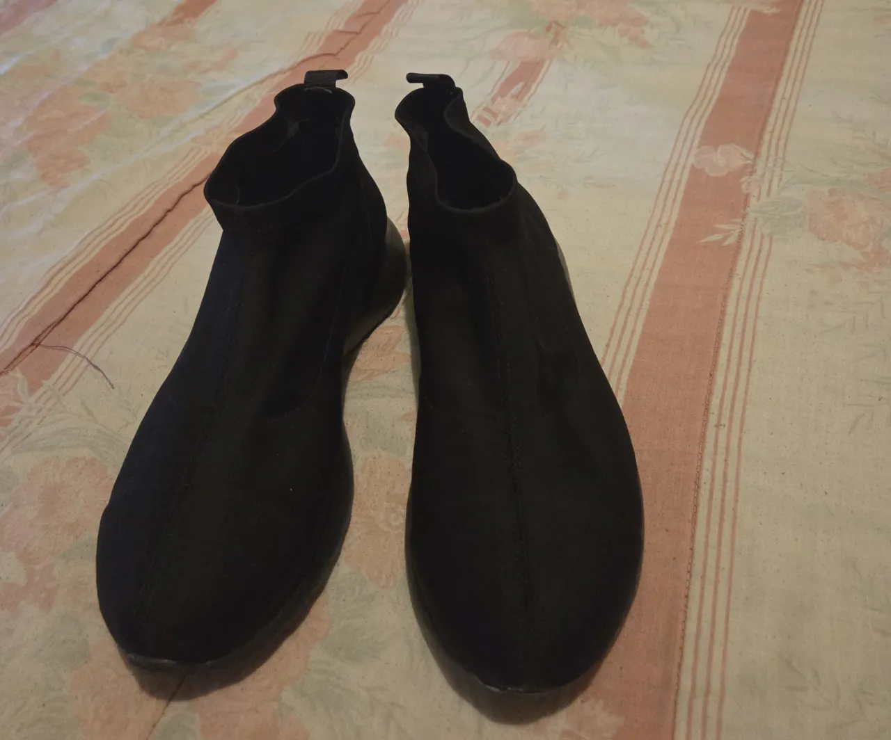 Zapatillas tipo botín de color negro, ideales para un look casual y moderno. Confeccionadas en un tejido elástico que se adapta al pie, brindando comodidad y estilo. Perfectas para combinar con diferentes outfits.