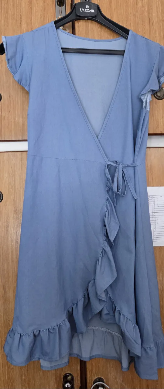 Vestido mini  celeste con diseño envolvente, volados en el borde y mangas cortas con volados. Ideal para un look casual y fresco.