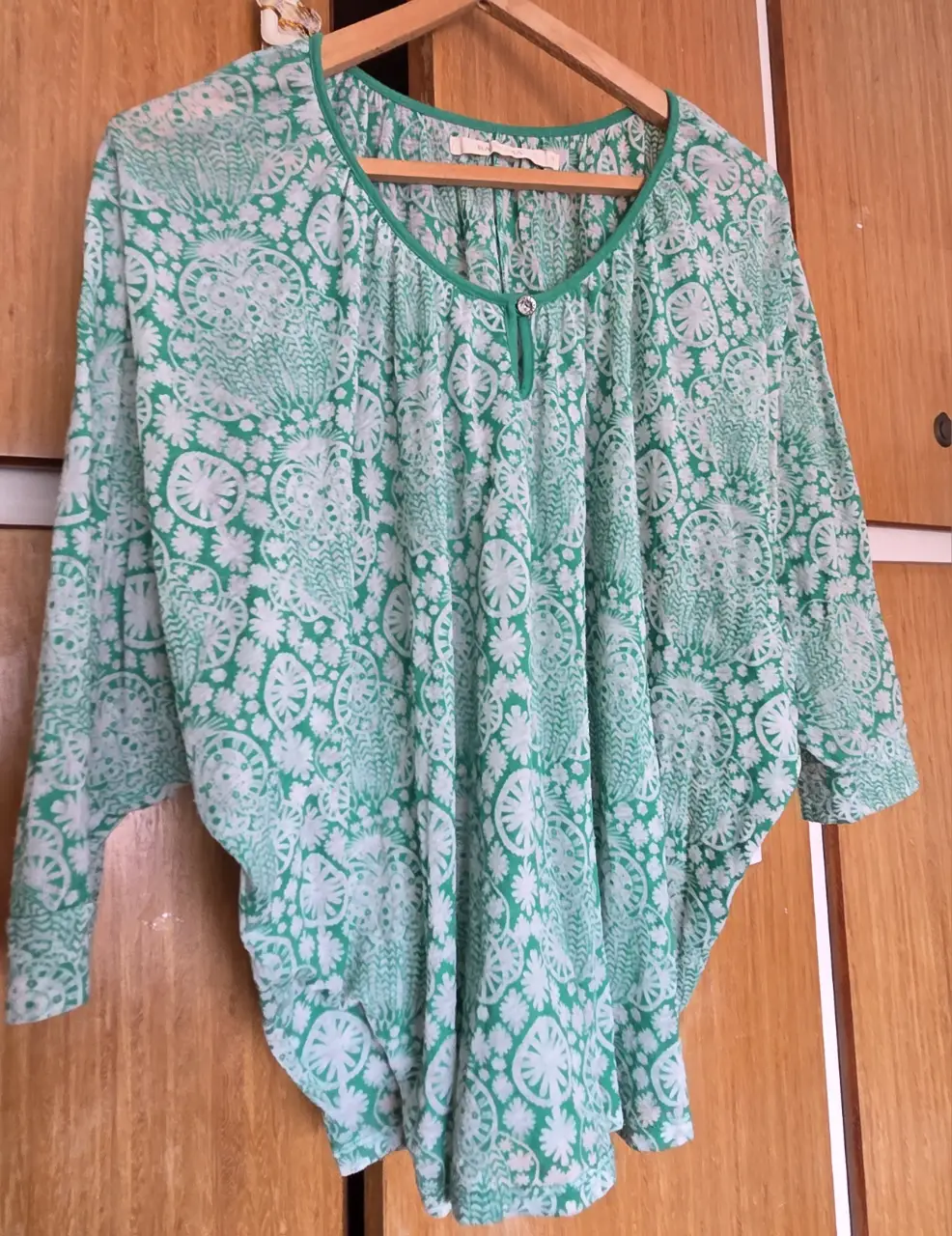 Blusa de mujer con estampado floral en tonos verde y blanco. Diseño holgado con mangas 3/4 y cuello redondo. Ideal para un look casual y fresco.