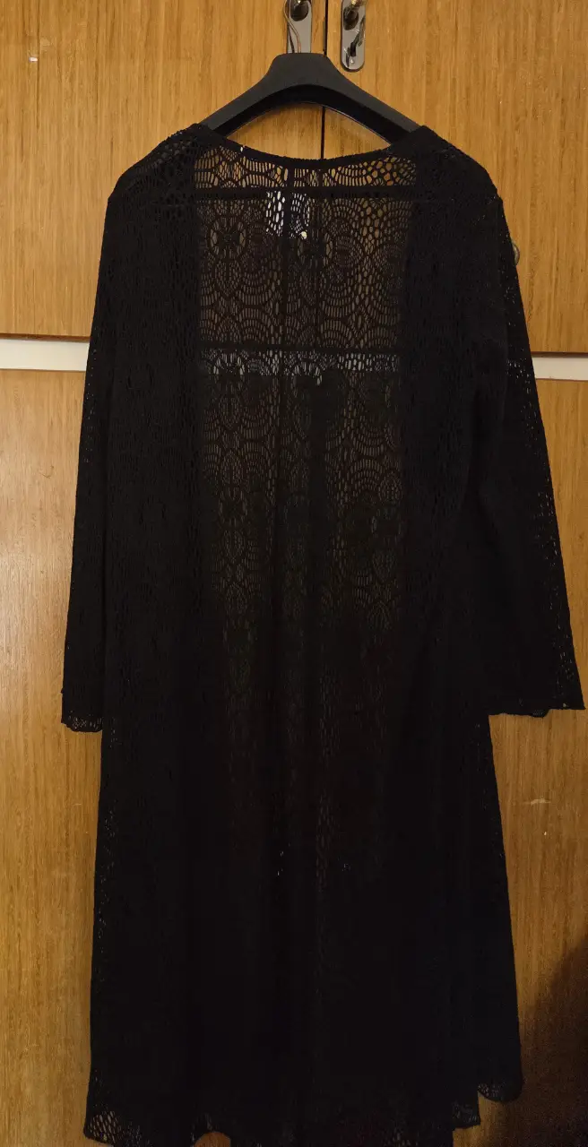 Elegante cardigan largo de encaje negro, ideal para complementar cualquier outfit con un toque sofisticado y femenino. Perfecto para usar en fiestas o salidas.
