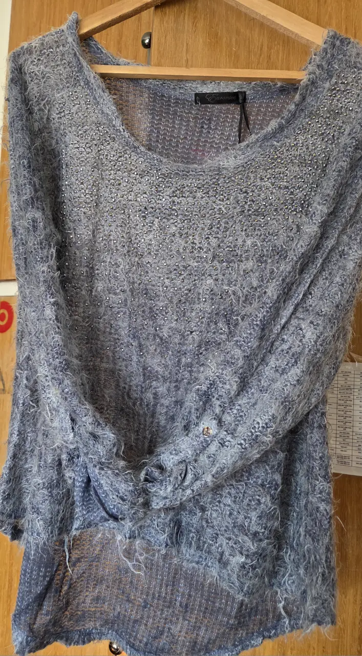 Sweater largo de mujer, tejido con detalles brillantes. Ideal para un look casual y abrigado.