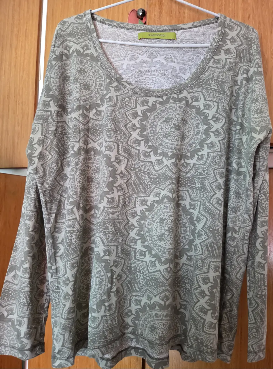 Remera de manga larga para mujer, con estampado floral en tonos grises. Cuello redondo y corte clásico. Ideal para un look casual y cómodo.