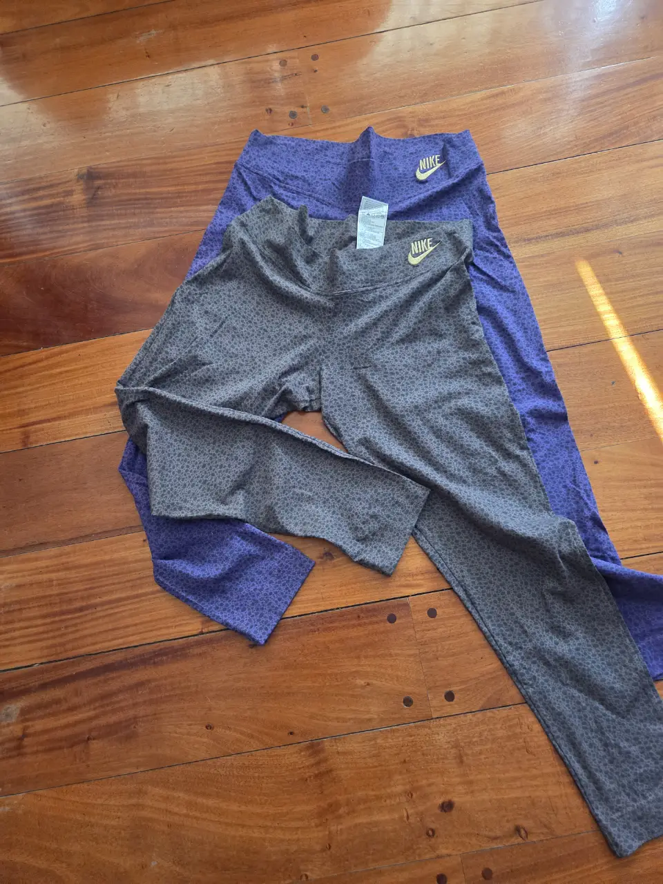 Calzas deportivas Nike, de color gris con estampado y violeta liso. Ideales para entrenar.