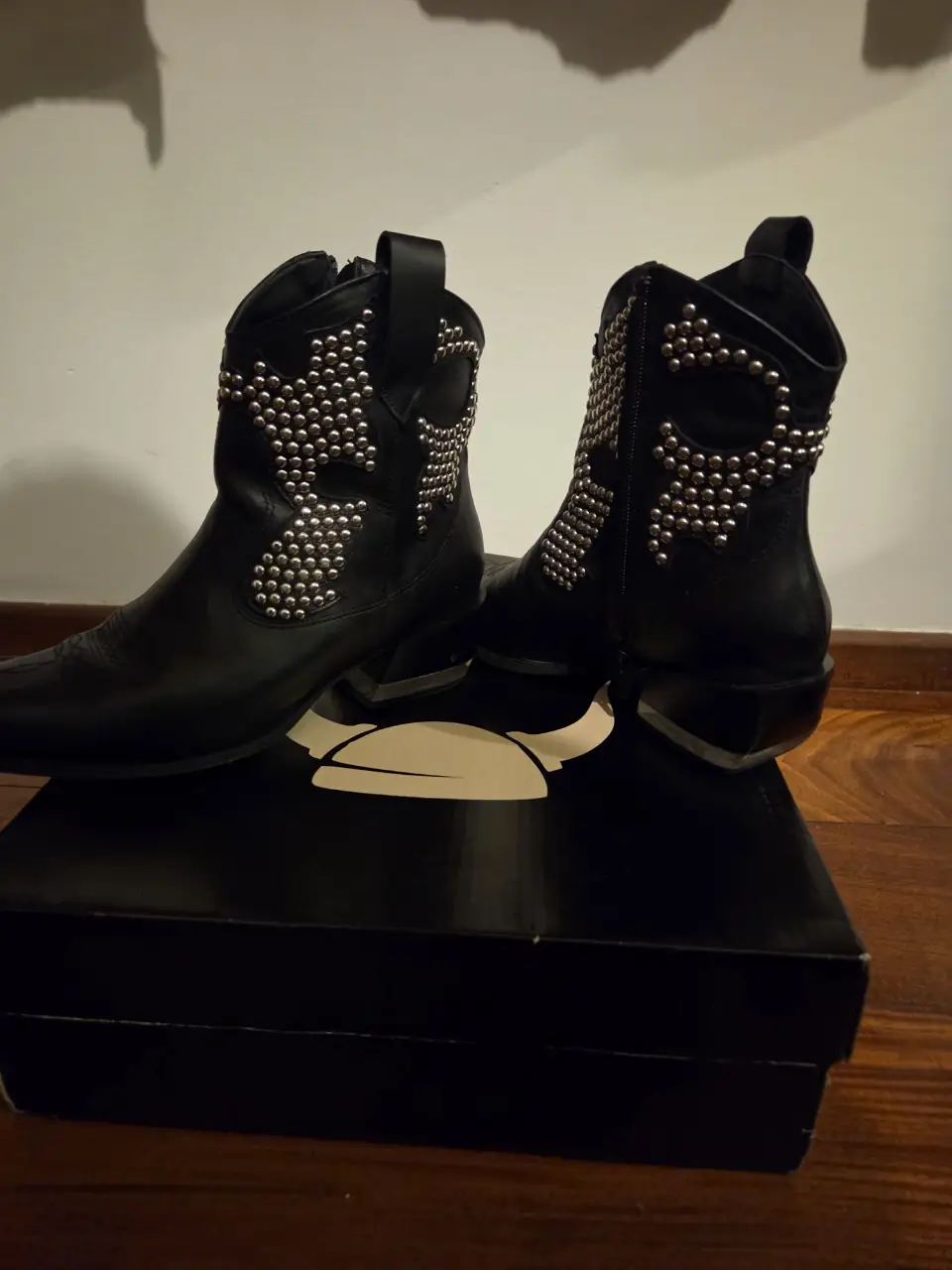 Botas de cuero negro con tachas plateadas, estilo rocker. Ideales para un look audaz y moderno.