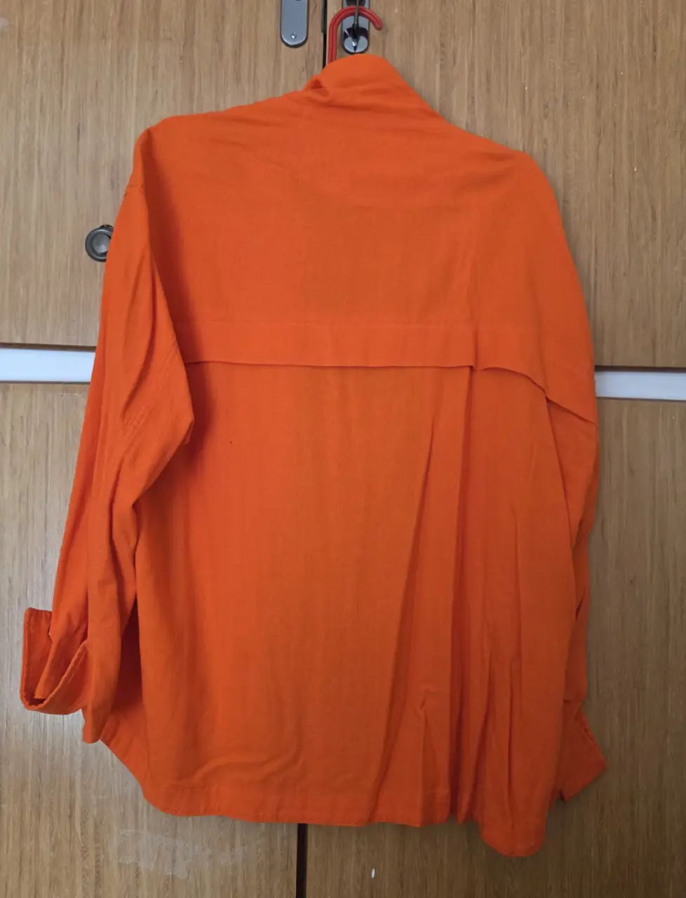 Camisa naranja de mujer, con cierre y bolsillos. Ideal para un look casual y moderno.