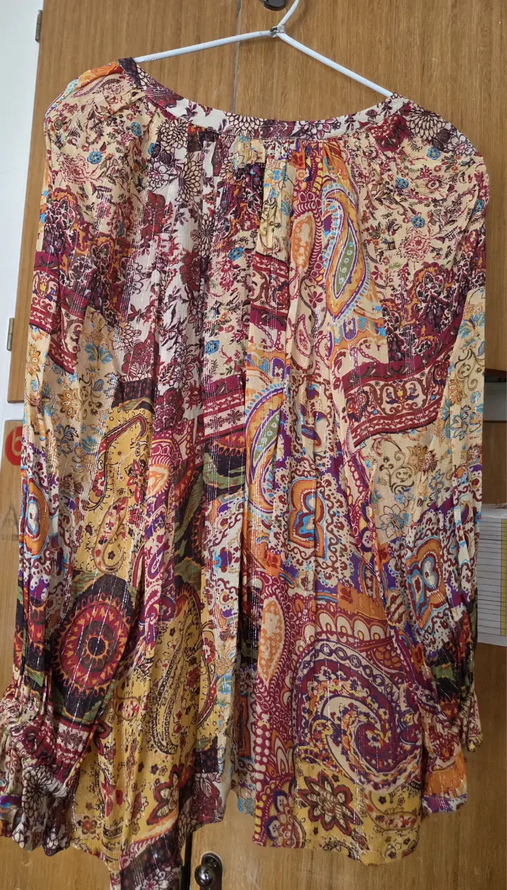 Blusa estampada con diseño paisley, manga larga y cuello en V. Ideal para un look bohemio y con estilo.