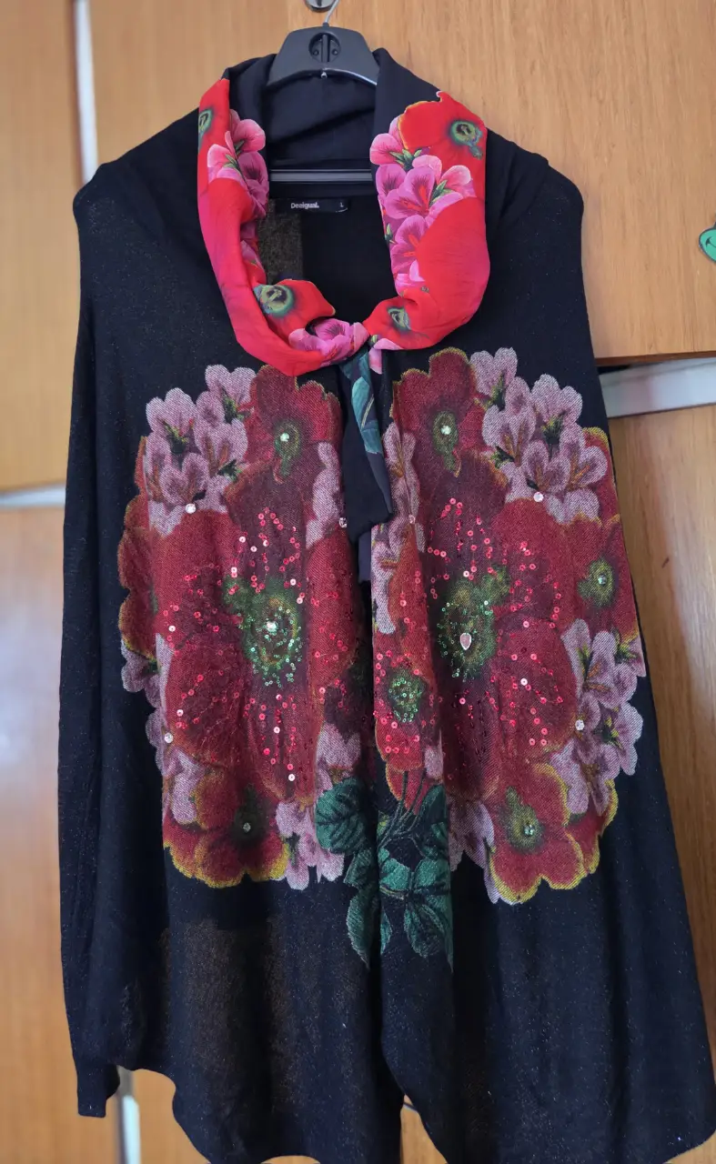 Sweater largo negro con estampado floral en tonos rojos y detalles de lentejuelas. Incluye un pañuelo rojo con estampado floral para usar como bufanda. Ideal para un look casual y con estilo.Es l pero va hasta xl