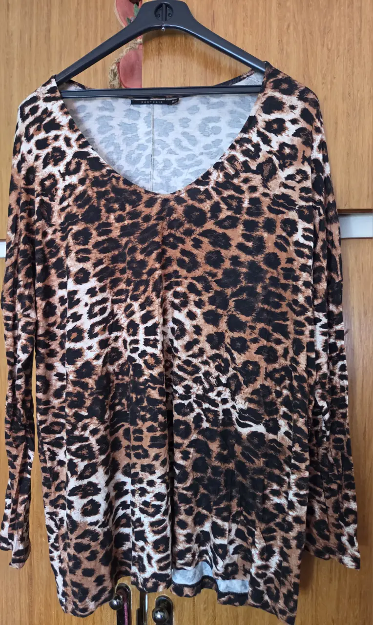 Blusa de mujer con estampado de leopardo, manga larga y cuello en V. Ideal para un look casual y moderno.