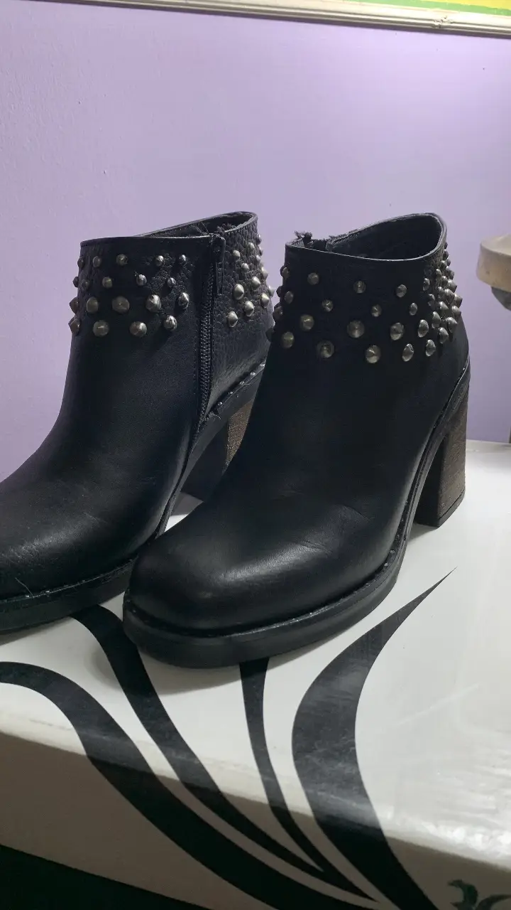 Botines negros de cuero con tachas plateadas en el borde superior y taco de madera. Ideales para un look rocker y canchero. Marca Lola Roca. Taco de 8 cm