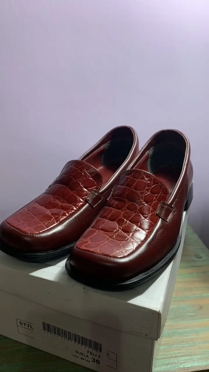 Mocasines en cuero color bordó con detalle de textura símil cocodrilo en la puntera. Ideales para un look elegante y sofisticado.