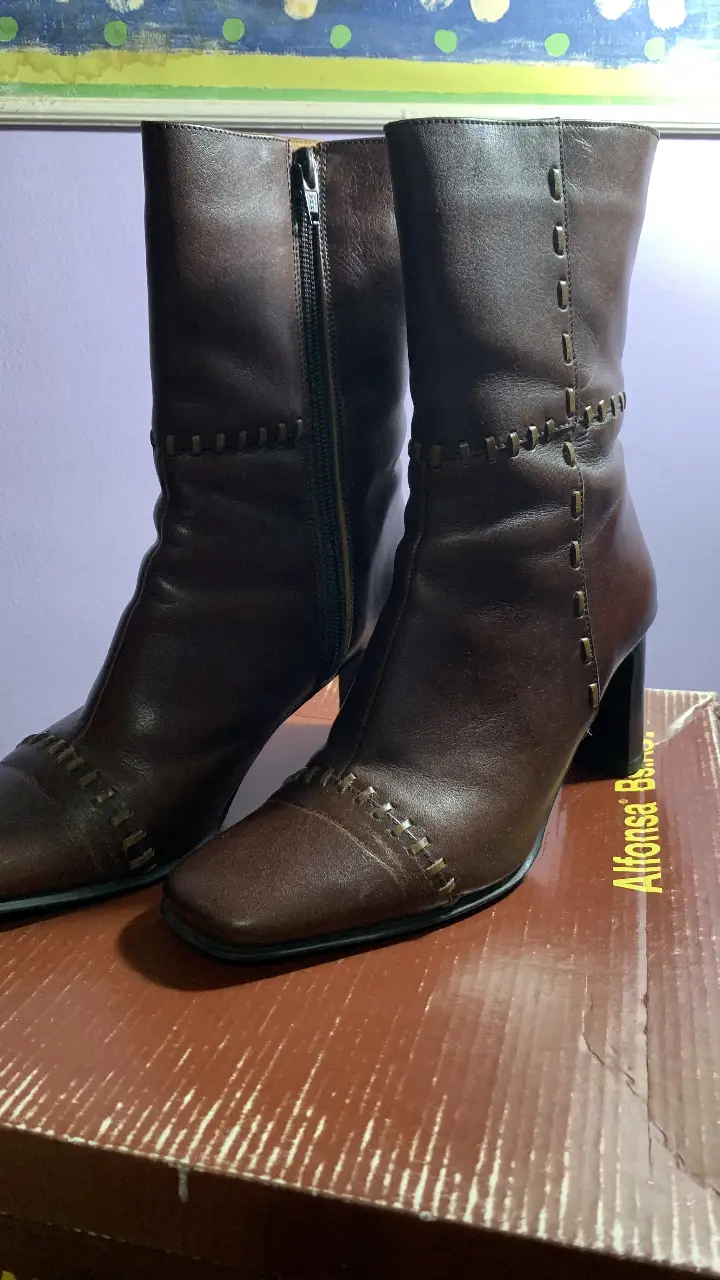 Botas de caña alta de cuero marrón con detalles de costura y cierre lateral. Ideales para un look elegante y sofisticado. Taco de 8 cm