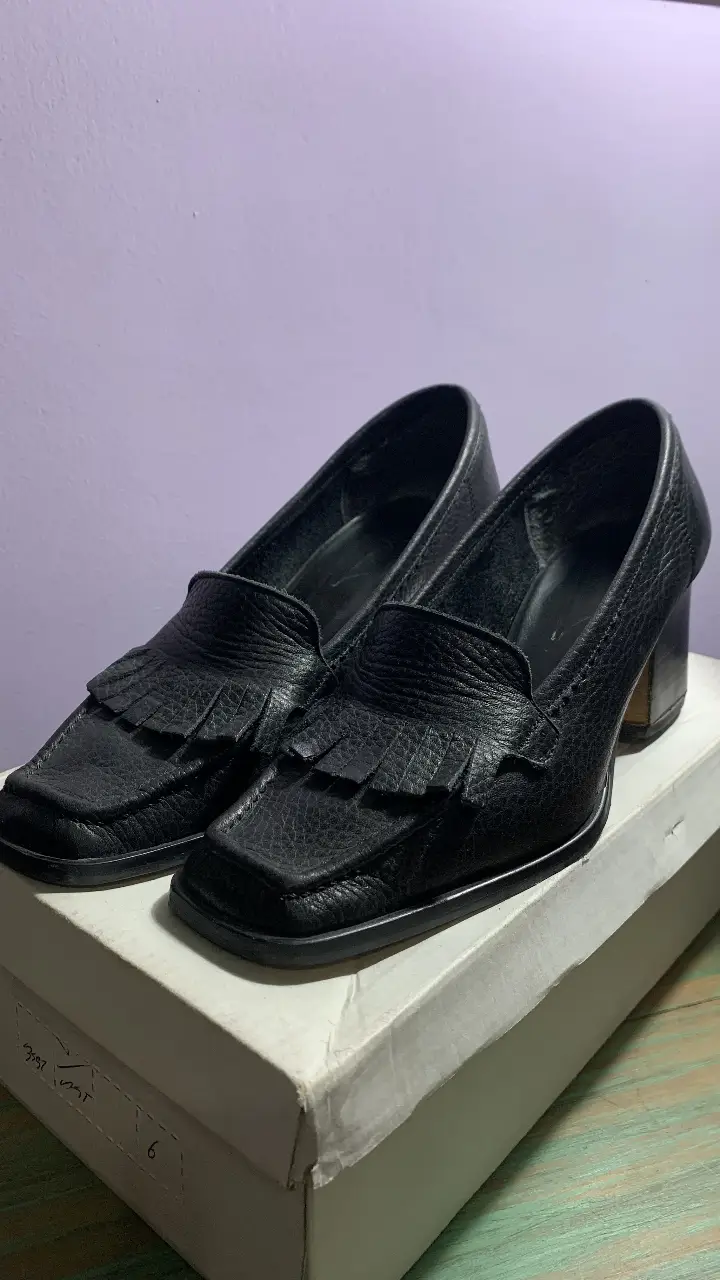 Zapatos de taco alto negros con diseño de mocasín y flecos. Ideales para un look elegante y sofisticado. Taco de 6 cm