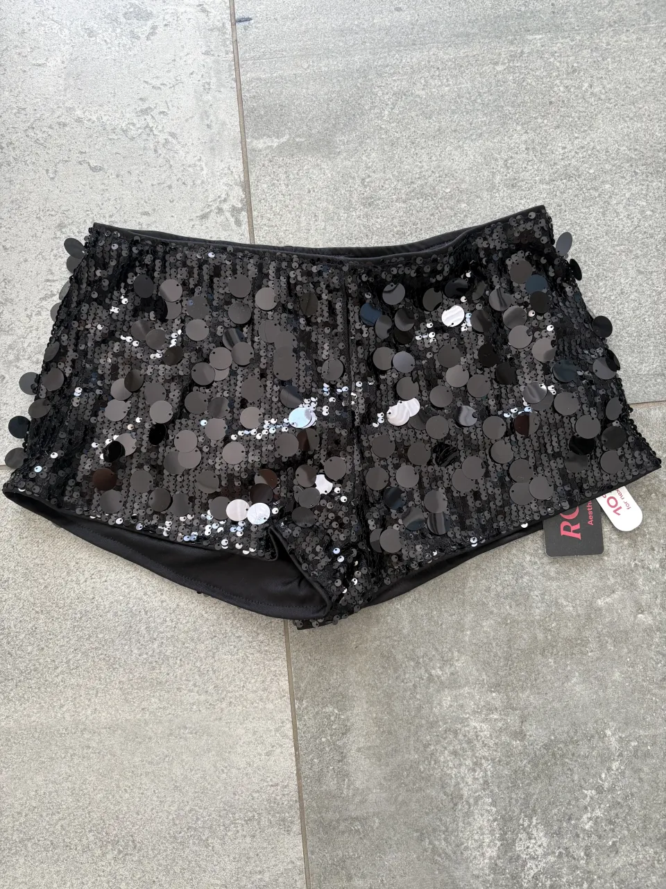 Shorts negros con lentejuelas circulares y detalles de lentejuelas en los laterales.