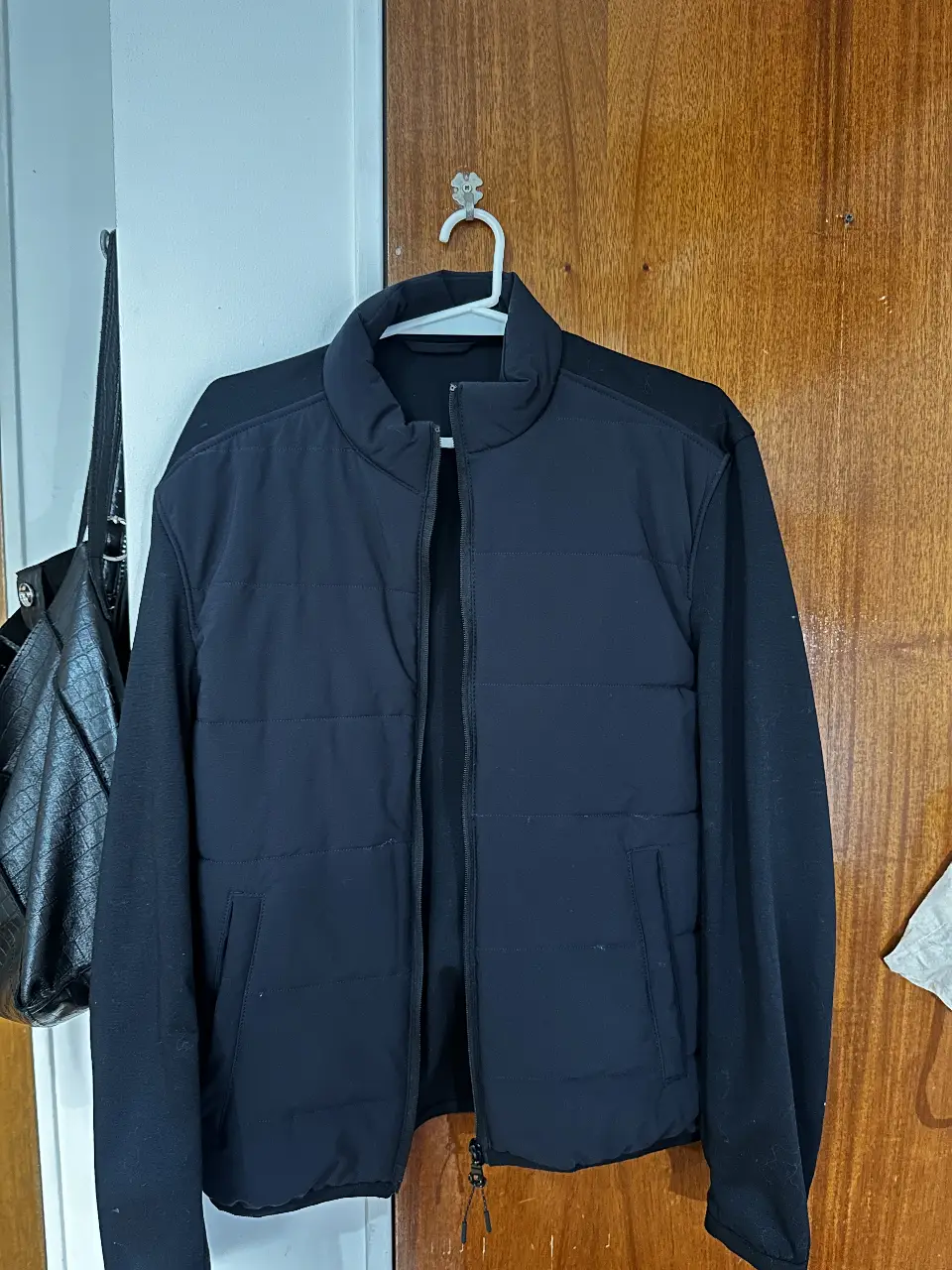 Campera bomber negra para hombre, con cuerpo acolchado. Ideal para el invierno, con cierre frontal y cuello alto.