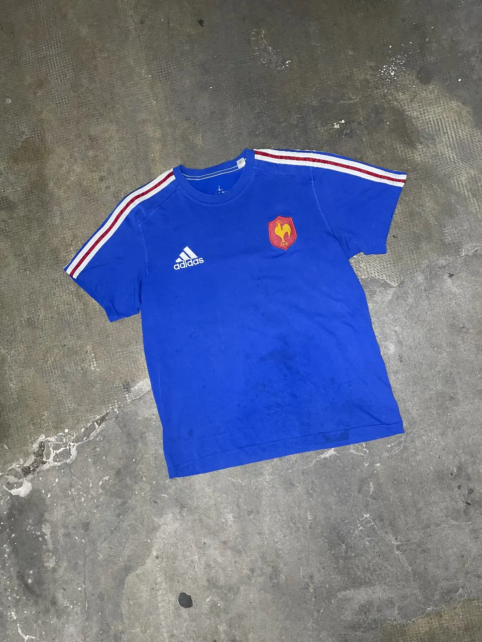 Remera de la selección de Francia, azul con detalles en blanco y rojo. Logo de Adidas y escudo de la federación francesa. Ideal para fanáticos del fútbol.