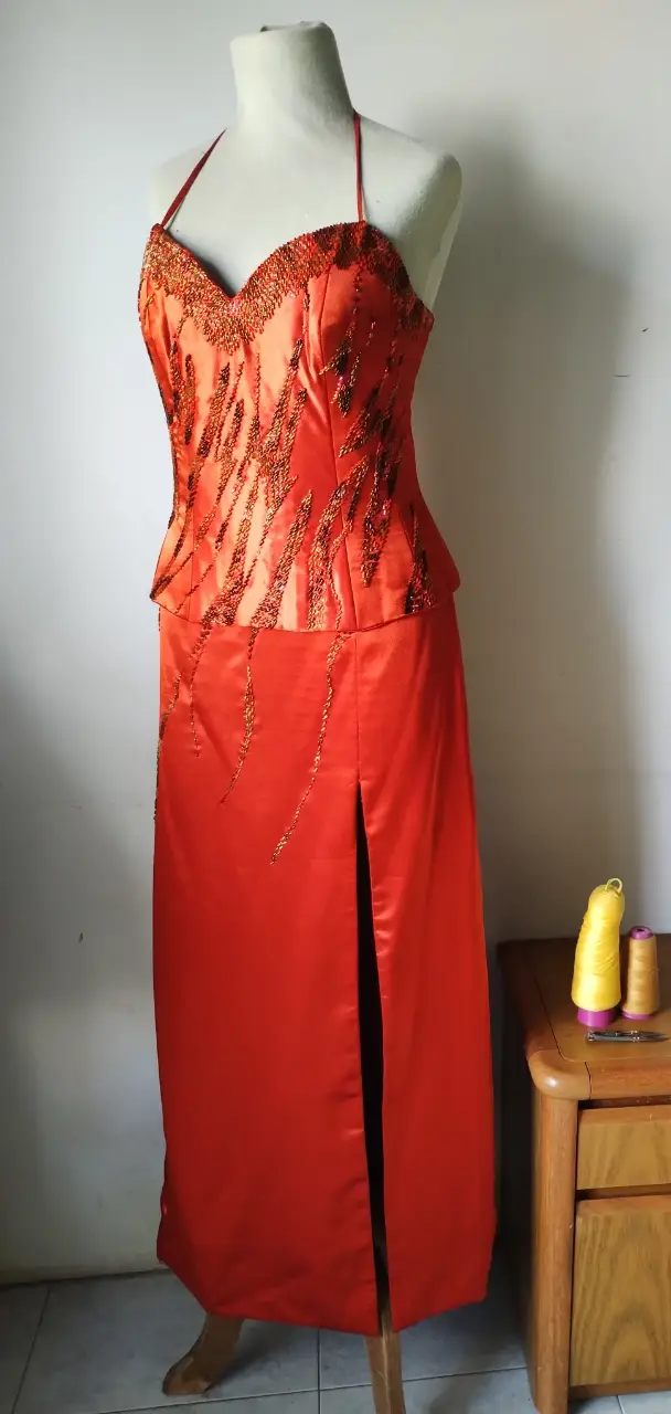 Vestido largo de fiesta naranja con detalles bordados en el corpiño y abertura en la pierna. Ideal para eventos especiales.