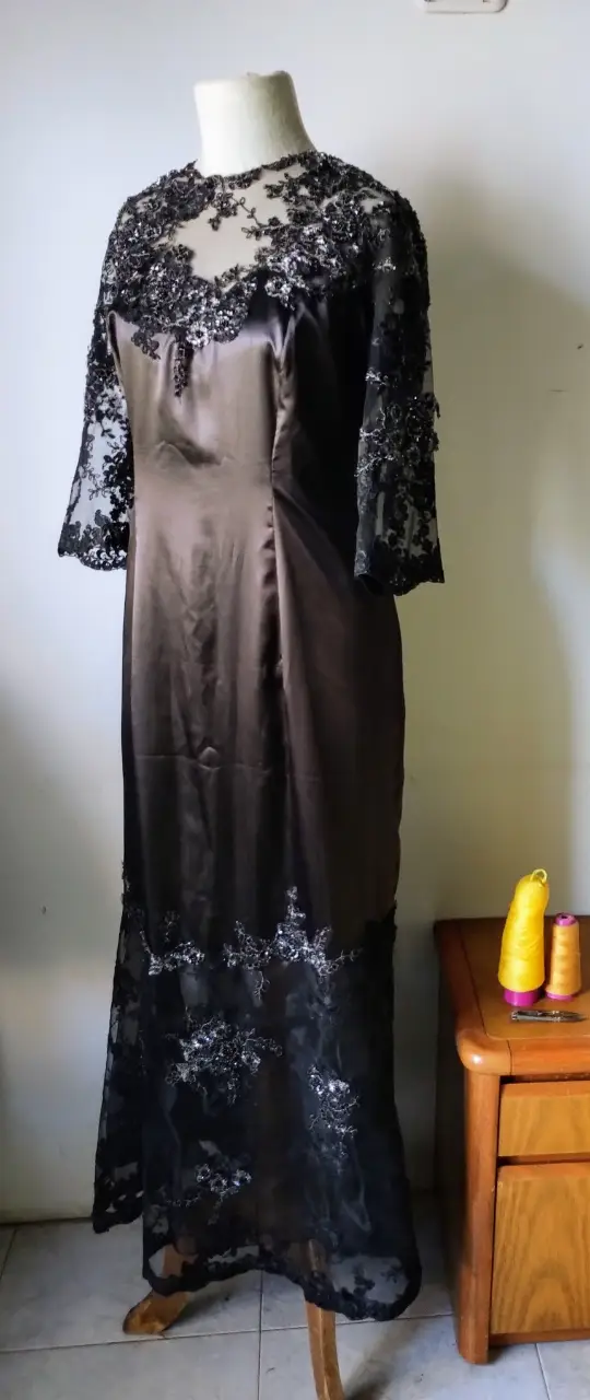 Vestido largo de fiesta con detalles de encaje en mangas y falda. Ideal para eventos formales.