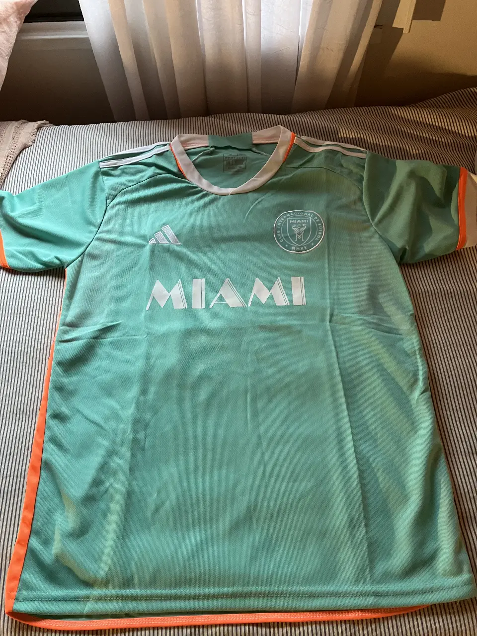 Camiseta de fútbol del Inter de Miami, con el número 10 de Messi. Color verde agua con detalles en naranja y blanco.