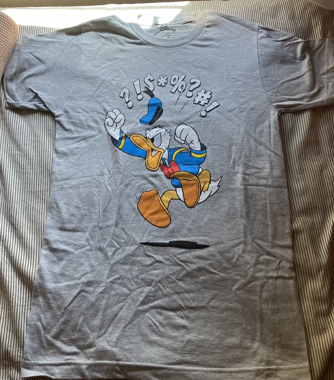 Remera gris con estampado de Donald enojado. Diseño divertido y original, ideal para un look casual y con onda. Marca Disney.