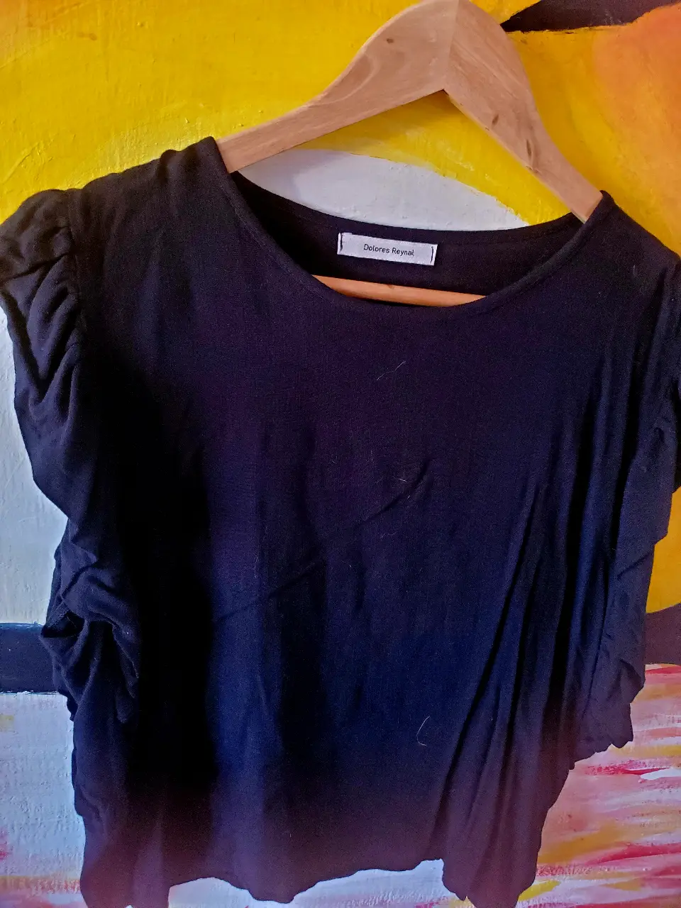Remera negra de mujer, con mangas cortas con volados. Ideal para un look casual y cómodo.