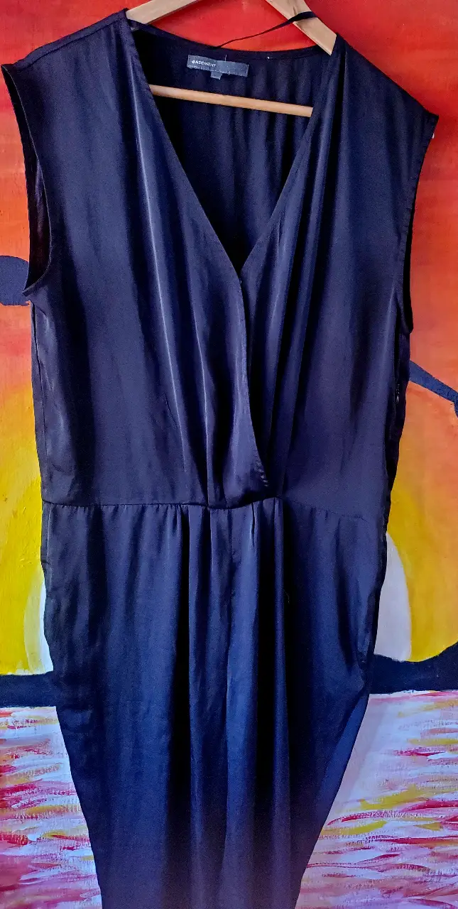 Vestido midi negro, elegante y versátil. Confeccionado en un tejido suave y fluido, presenta un diseño cruzado en el frente con un favorecedor escote en V. Ideal para eventos formales o para darle un toque sofisticado a tu día a día.