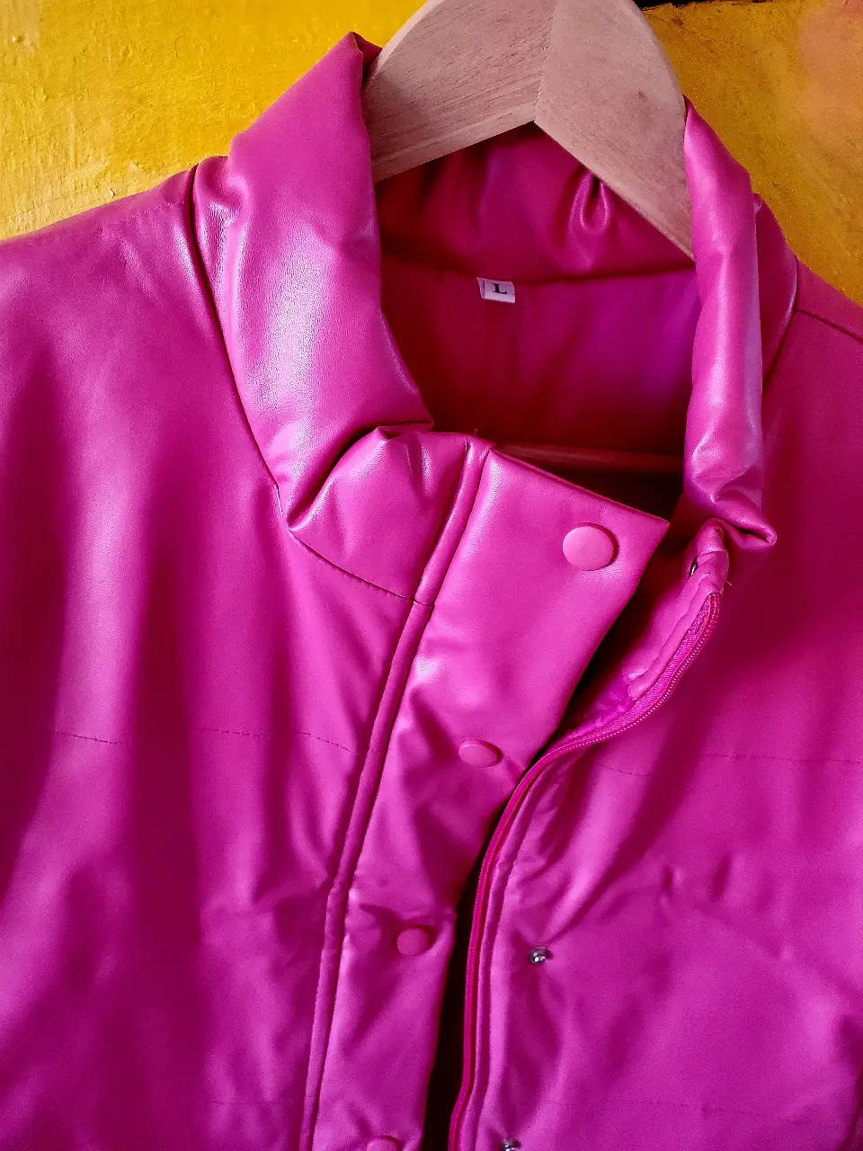 Campera bomber fucsia de cuero sintético, con cuello alto y cierre. Ideal para un look moderno y audaz.
