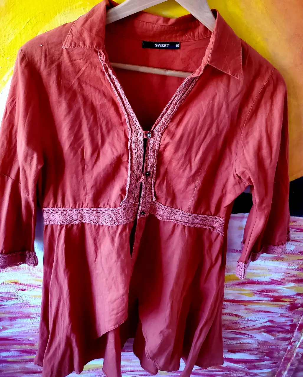 Blusa naranja con detalles de encaje, ideal para un look casual y femenino. Confeccionada en tela ligera y cómoda, perfecta para el día a día. Diseño con botones y mangas 3/4.