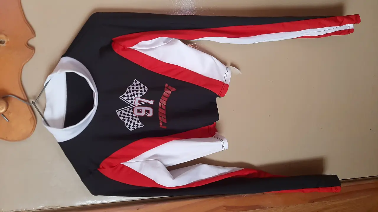 Remera manga larga deportiva para hombre, con diseño de carreras. Combina negro, blanco y rojo. Estampado "Racing 97" con banderas a cuadros.