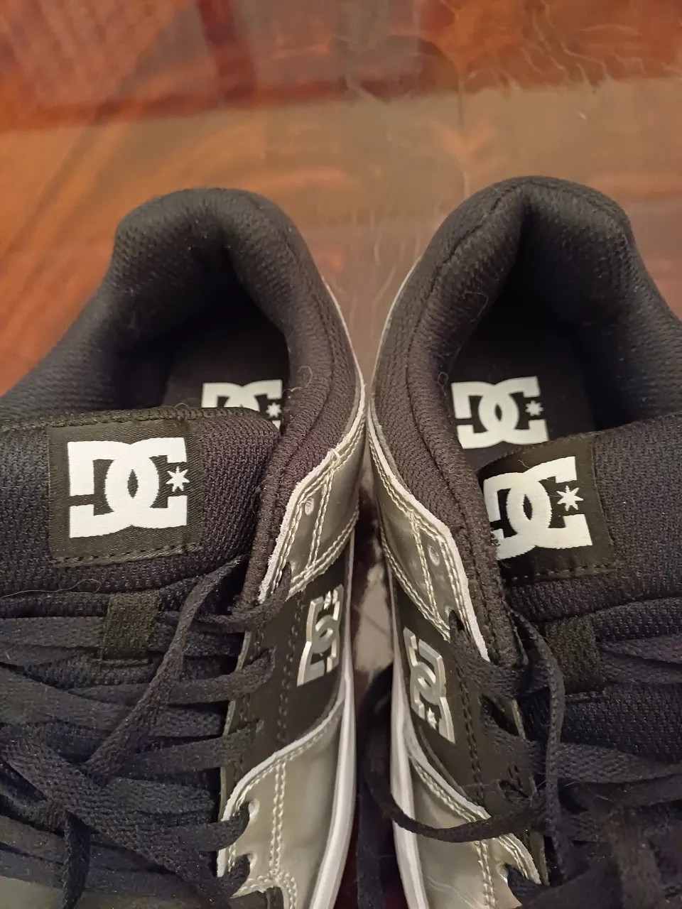 Zapatillas DC Shoes color negro y plateado, con cordones. Ideales para un look skater o casual.
