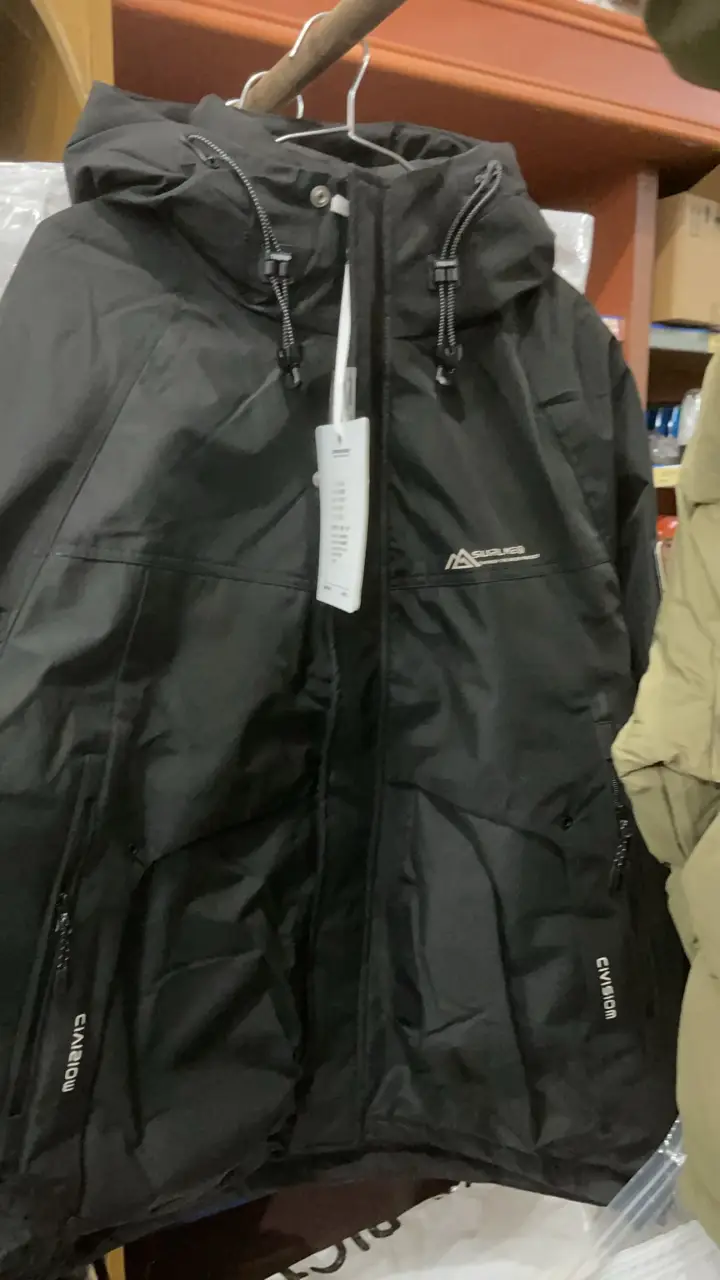 Campera de Pluma negra con capucha y cierre. Ideal para actividades al aire libre o uso diario en climas fríos. Posee bolsillos con cierre y detalles.