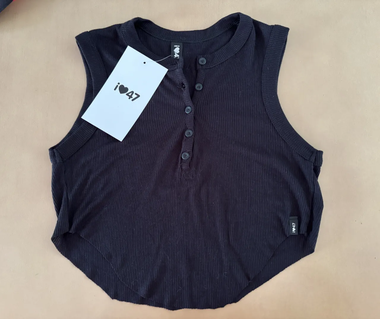 Musculosa negra de morley, con botones al frente y escote redondo. Ideal para un look casual y canchero.