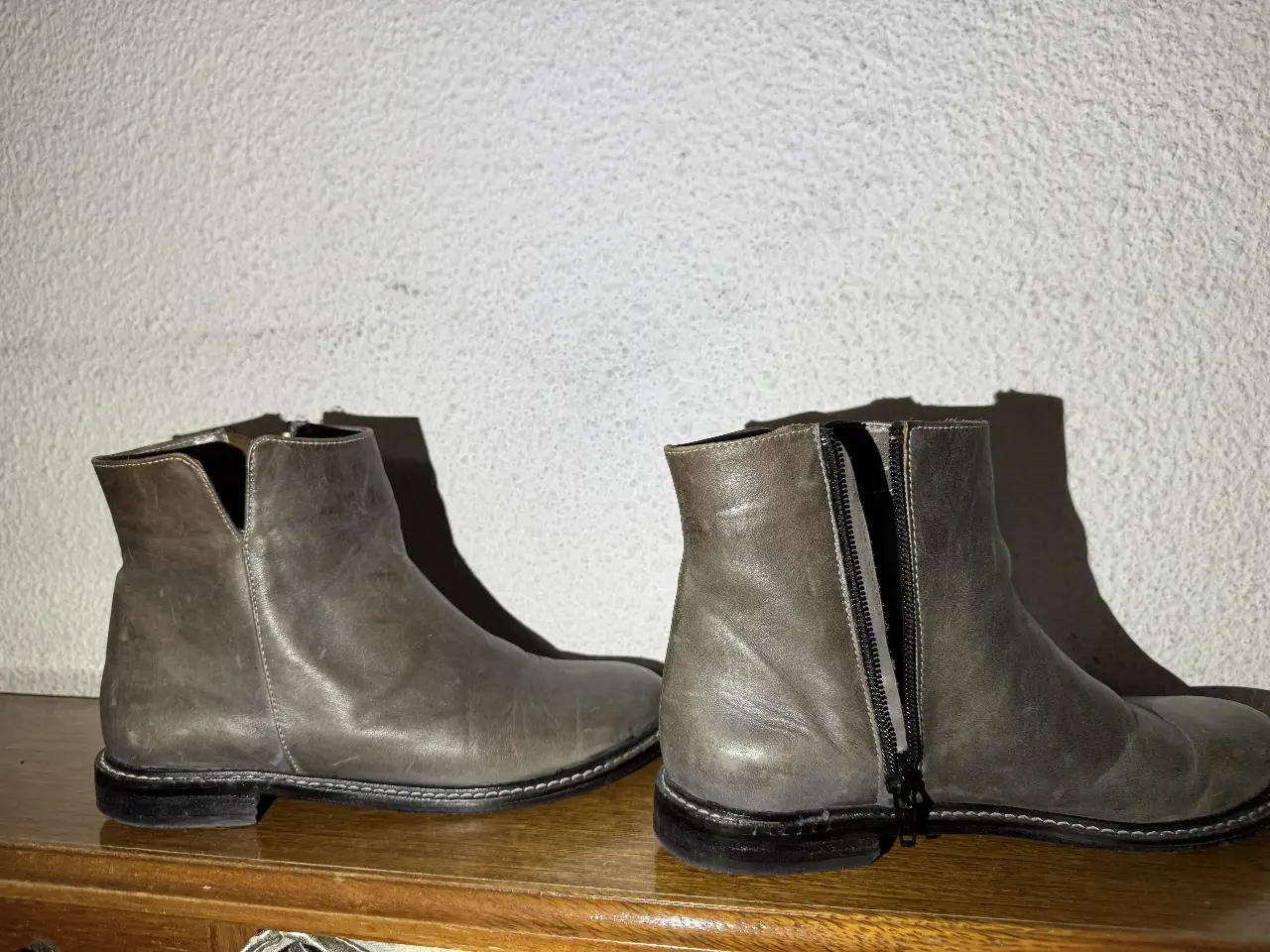 Botines de cuero grises. Diseño clásico con cierre lateral y suela de goma.
