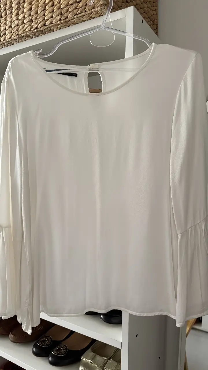 Blusa blanca de manga larga con detalles de volados en las mangas. Ideal para un look elegante y sofisticado.