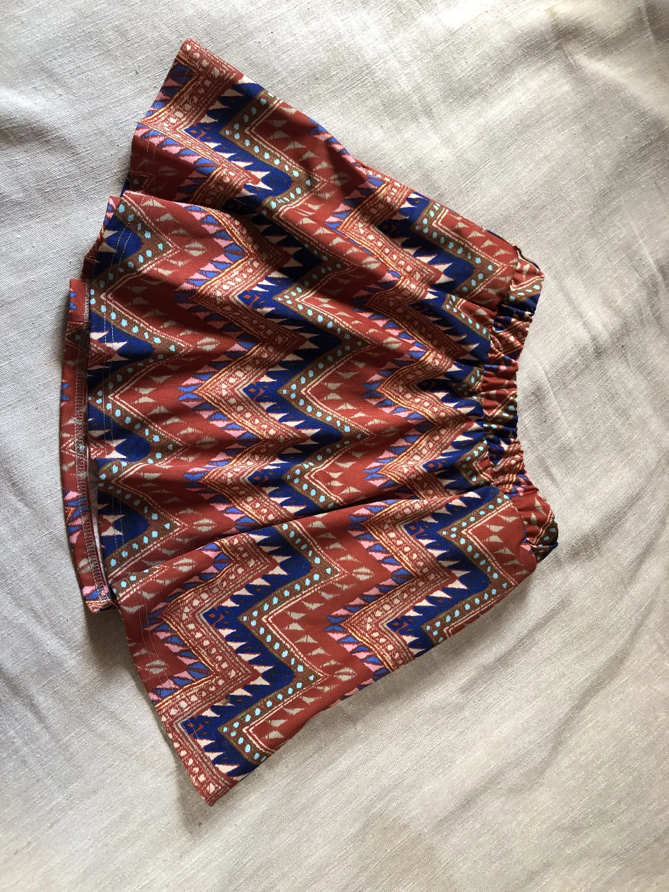 Pollera de tela con estampa étnica vibrante, ideal para un look relajado y con onda. Posee cintura elastizada para mayor comodidad. Con forro y bolsillos.