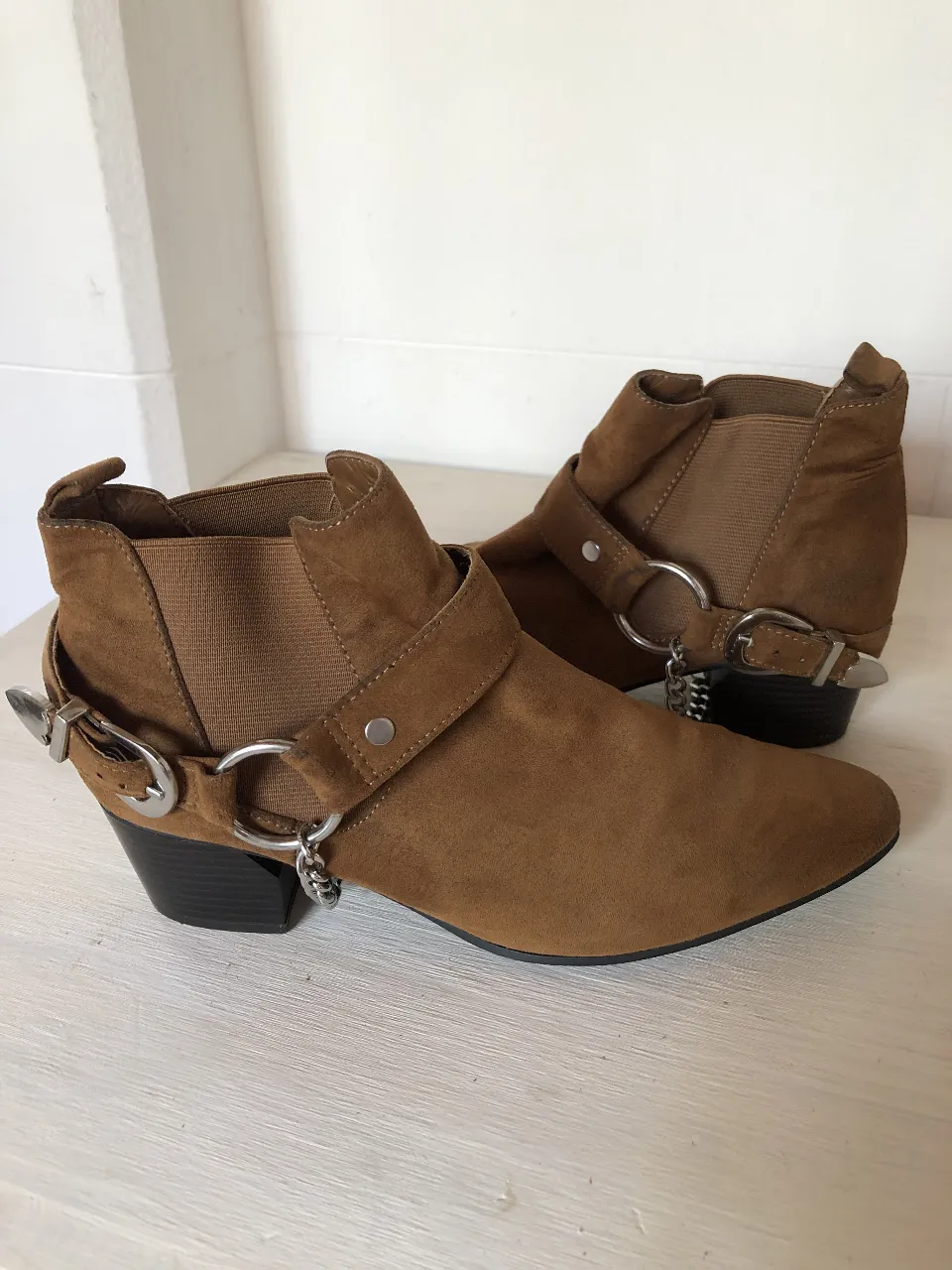 Botitas de gamuza color suela con hebillas y cadenas. Un toque rockero y canchero para tus looks.