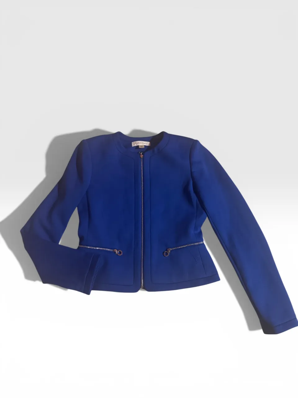 Blazer azul eléctrico con cierre metálico y bolsillos frontales con cierre. Un diseño moderno y elegante, perfecto para elevar cualquier look.