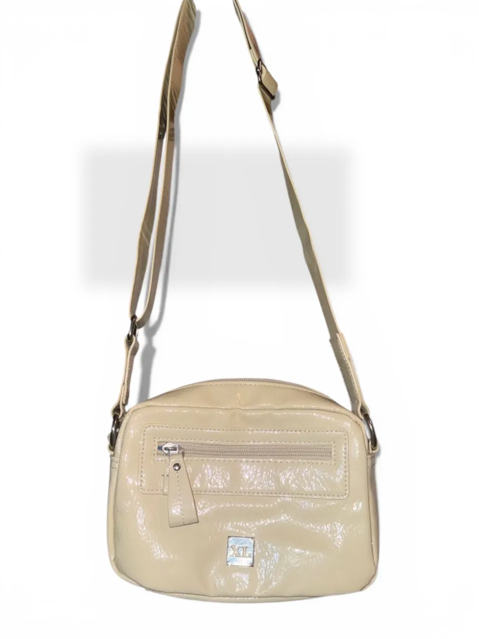 Cartera bandolera de cuero sintético color crudo, con cierre y bolsillo frontal. Ideal para el día a día o salidas casuales.