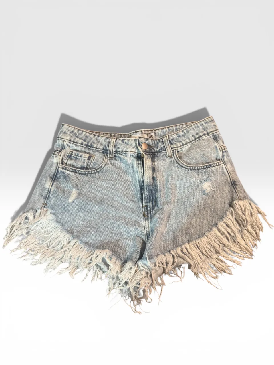 Shorts de jean tiro alto con roturas y flecos. Un clásico de verano que no puede faltar en tu guardarropa.
