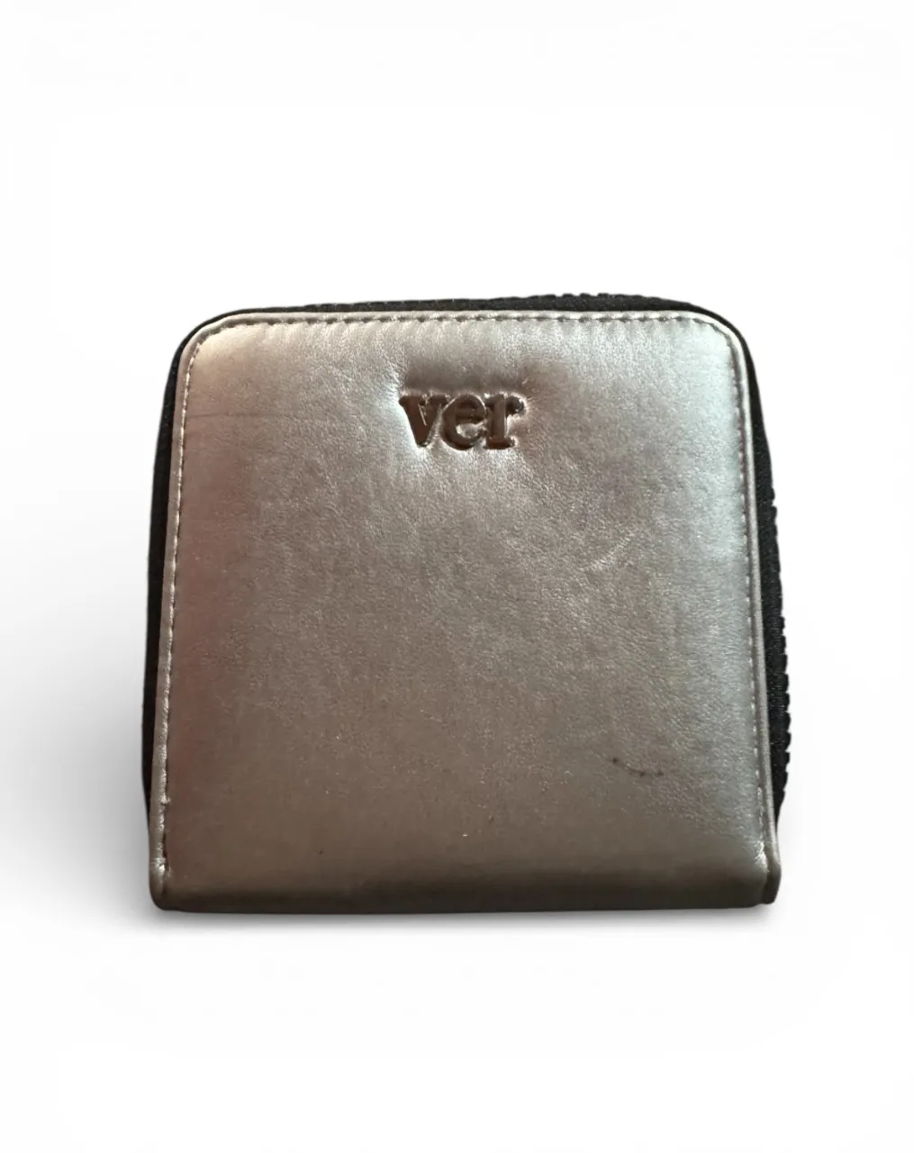 Billetera plateada con cierre y logo de la marca 'ver'.