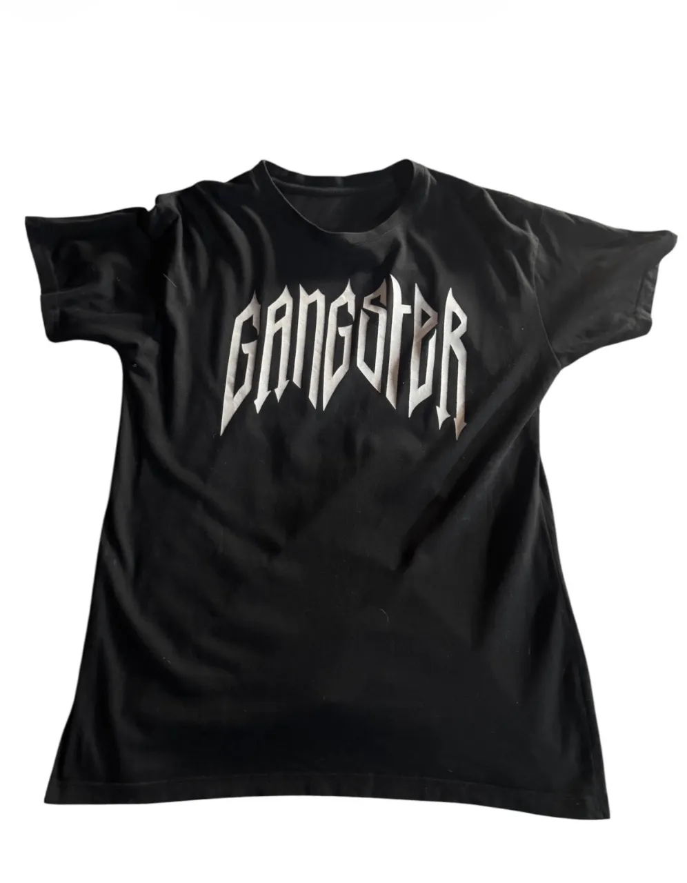 Remera negra con estampa en blanco en el frente y una estampa en la espalda con la palabra "SMILE" en rosa, junto a la imagen.Ideal para un look urbano y audaz.