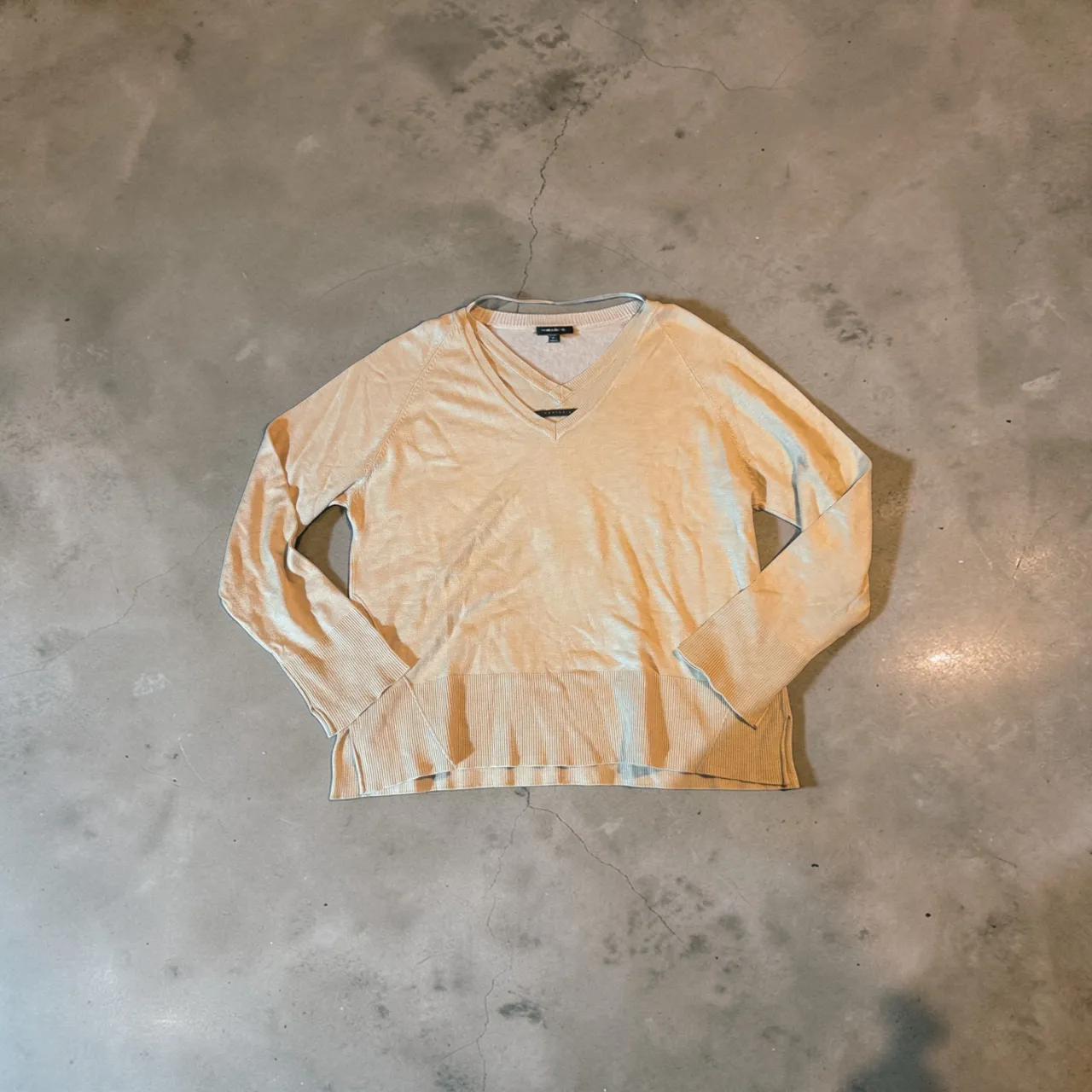 Sweater de hilo color crudo con cuello en V. Ideal para un look casual y elegante.