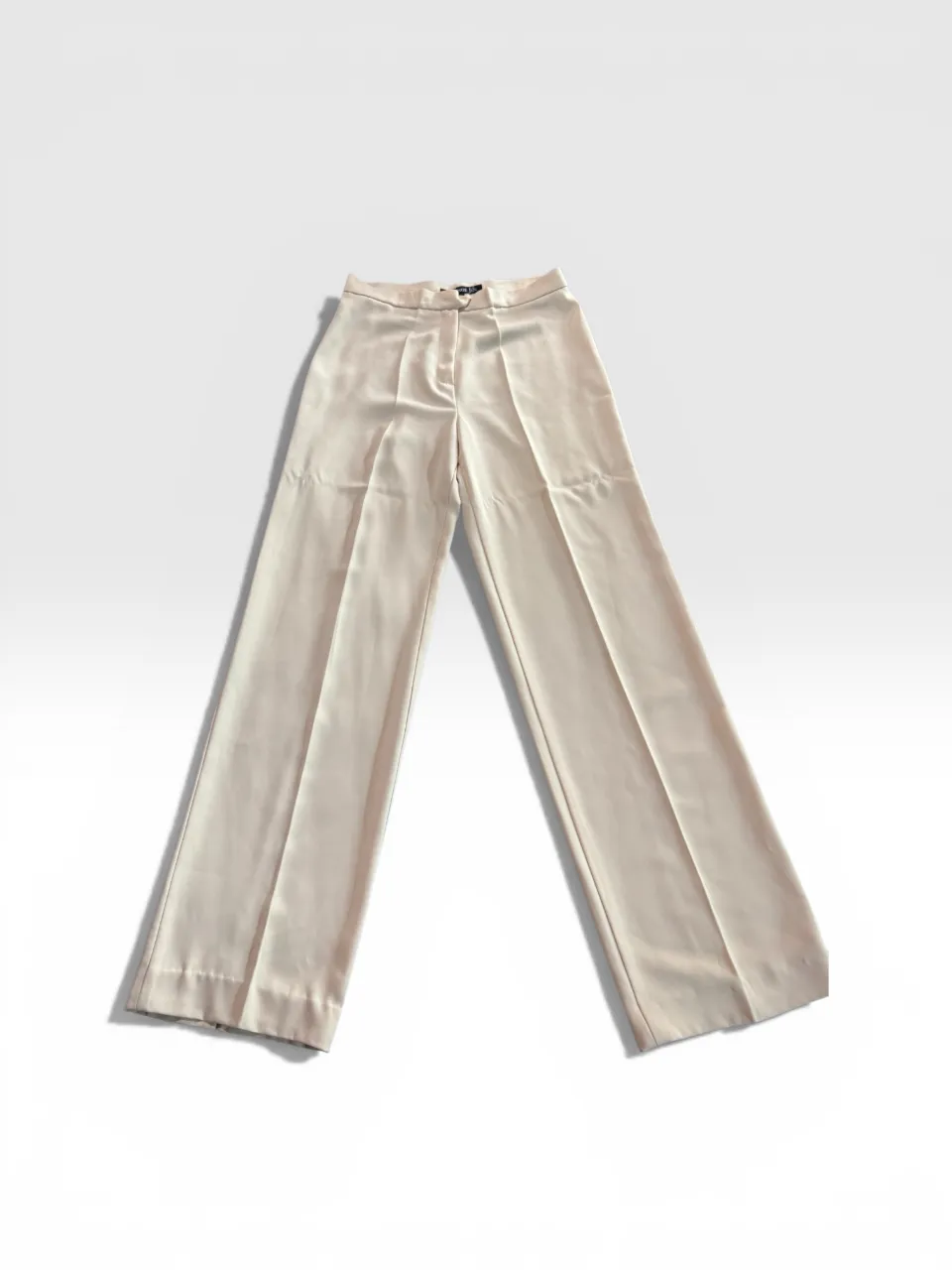 Pantalón palazzo de vestir color crudo, tiro alto, con pinzas y detalles de costura. Ideal para un look elegante y sofisticado.