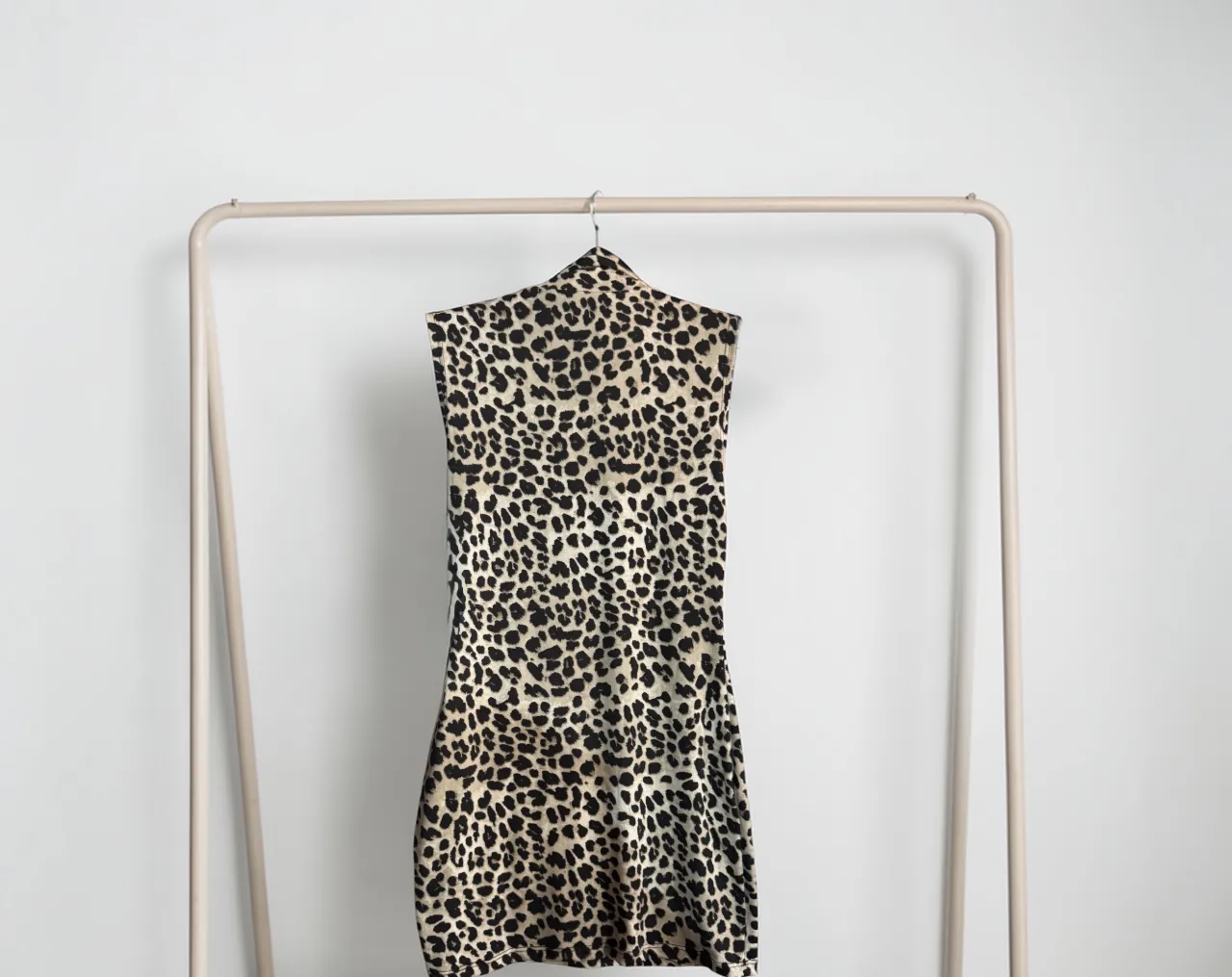 Vestido estampado de leopardo, sin mangas y con cuello alto. Ideal para un look audaz y a la moda.